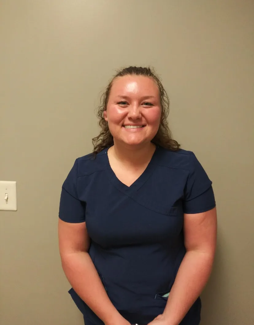Nicole's staff photo from Foothills Veterinary Hospital where she is wearing her blue scrubs.